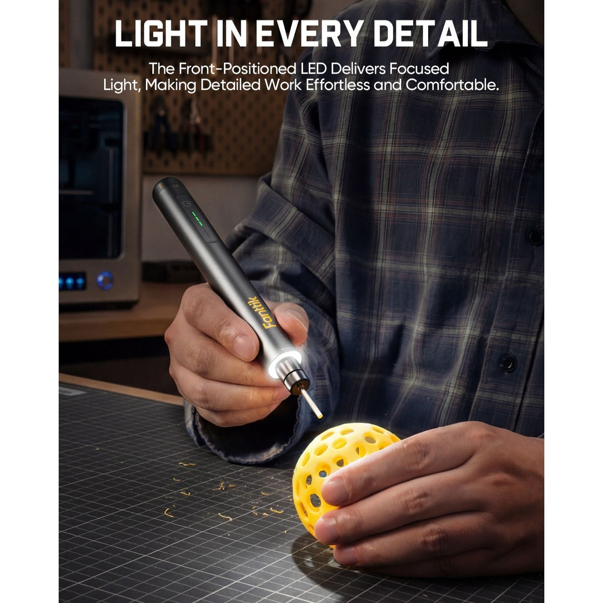 Cordless rotary tool with front LED light carving a yellow 3D model