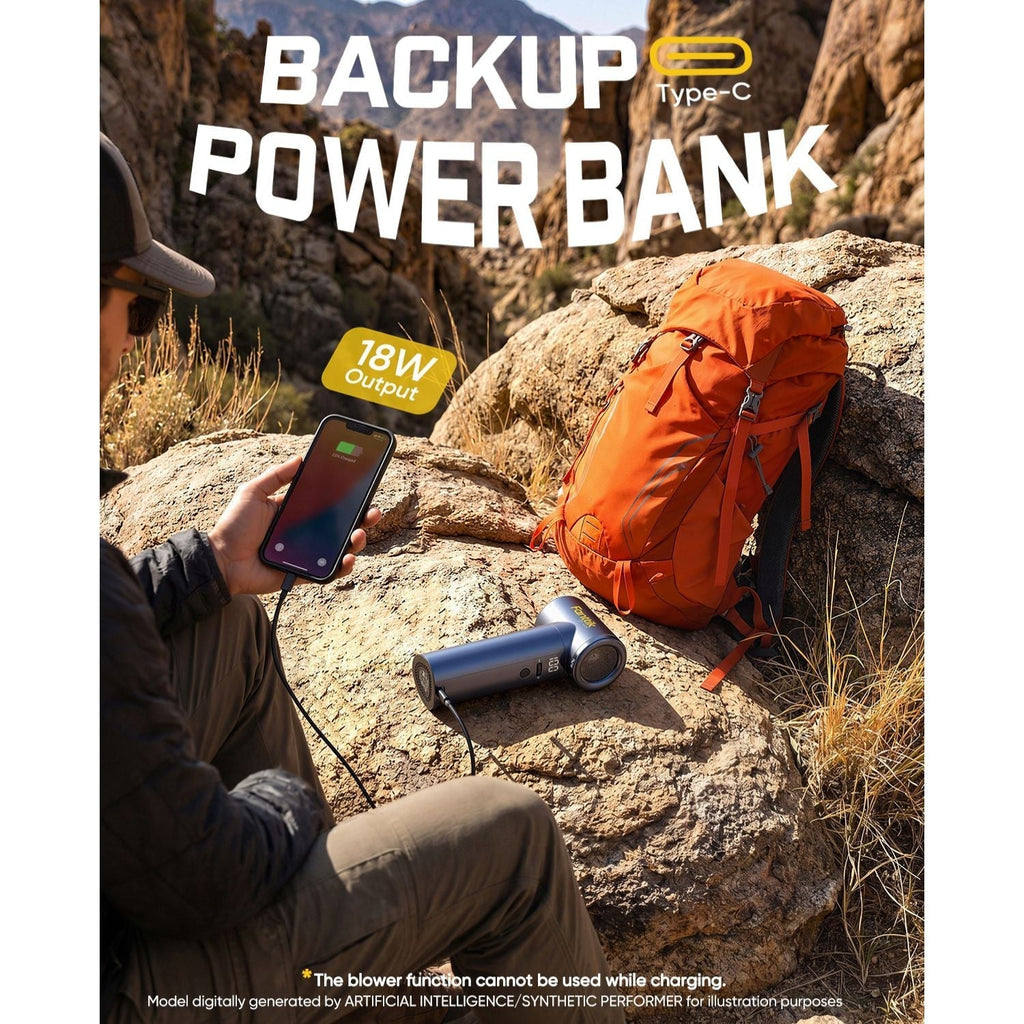 Person using a power bank in a desert setting with an orange backpack and a blower on a rock.