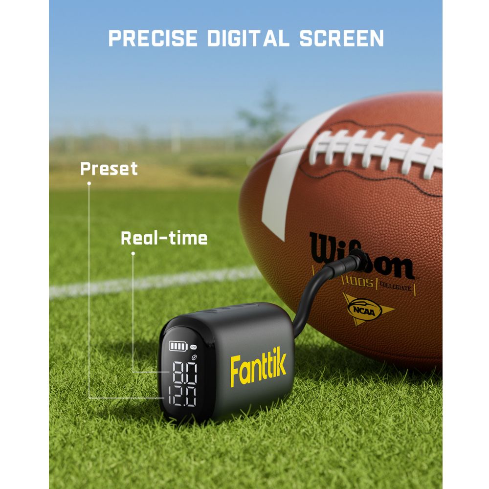 Fanttik X9 Nano electric ball pump with digital display next to a Wilson football on a sports field.