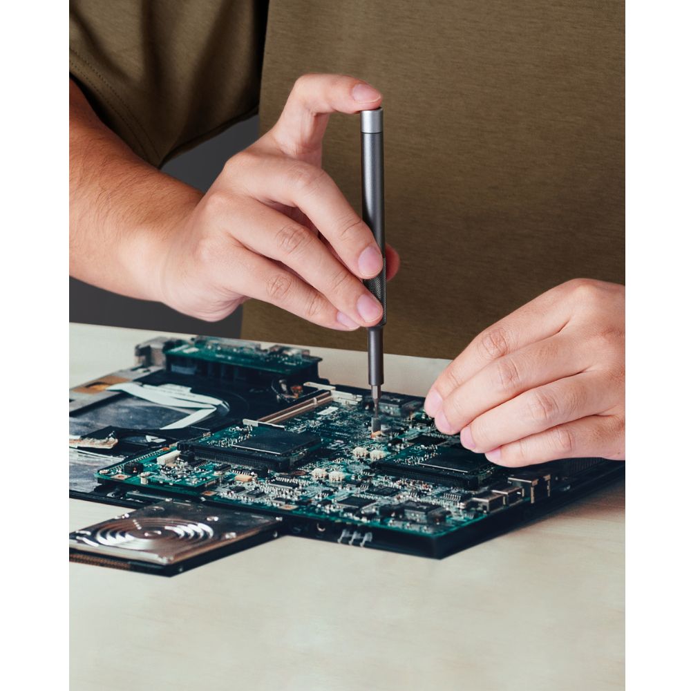 Fanttik X5 MAX precision screwdriver repairing a laptop motherboard
